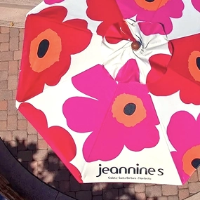 Custom full-print market umbrella for Jeannine's featuring vibrant pink, red, and orange florals