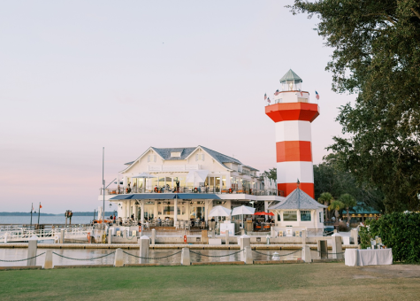 Sunset view of Sea Pines Resort with white cabana umbrellas visible in the distance.