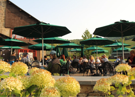 Gunstock Mountain Resort patio featuring green custom logo market umbrellas.