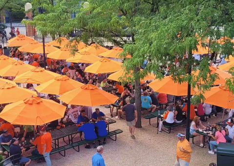 Orioles outdoor space with custom orange market umbrellas shading picnic tables