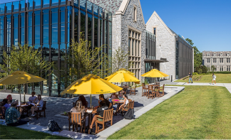 Custom branded Umbrella Source logo umbrellas in a university outdoor seating area highlighting camp
