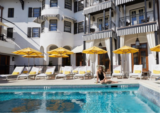 The Pearl Hotel rooftop pool lined with yellow market umbrellas.