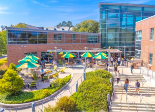 Siena University campus outdoor area featuring custom green and yellow branded market umbrellas.