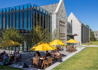 Oglethorpe University outdoor study and dining area with yellow branded umbrellas and students