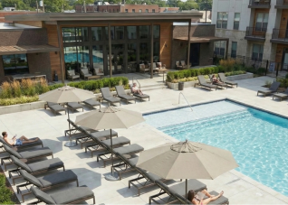 Market umbrellas surrounding an apartment complex pool.