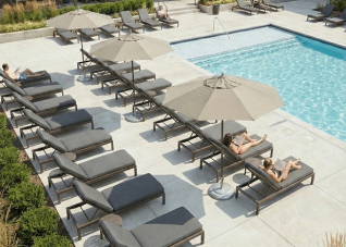 Apartment complex pool with rows of chaise lounges and custom gray cushions